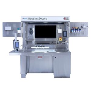 Front view of a Maestro Encore pathology grossing station, featuring a spacious stainless steel workspace and integrated technology. This high-tech station includes multiple storage areas, a large monitor, barcode scanner, and various other tools, designed for precision and efficiency in pathological sample preparation and examination.